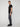 A man stands sideways against a light background, wearing a black t-shirt, PROJEK RAW MEN’S CANVAS BUNGEE PULL-ON CARGO JOGGER with pockets, and black sneakers. He faces the camera slightly with a neutral expression.