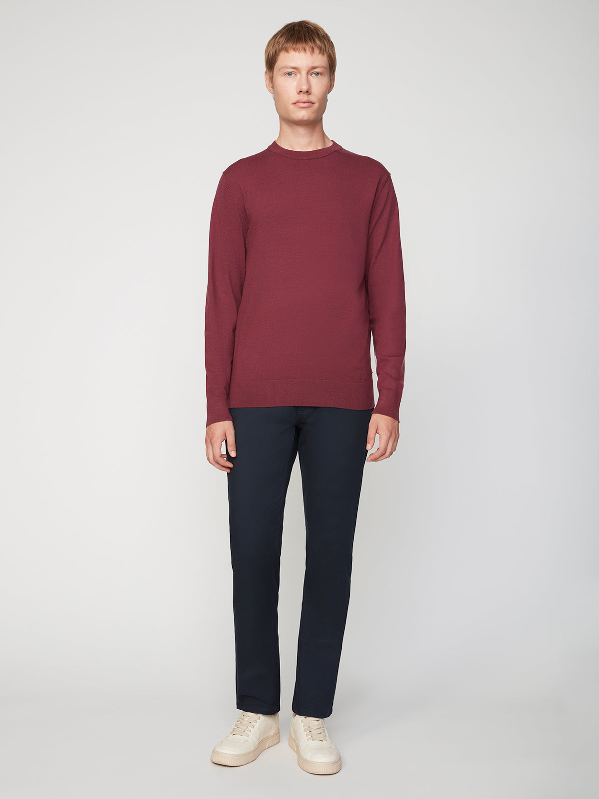 A person stands facing forward against a plain background, wearing a maroon long-sleeve shirt, PROJEK RAW MENS CANVAS BUNGEE 5-POCKET PANT in dark navy, and white sneakers.
