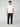 A young man with curly brown hair wears a white tee, PROJEK RAW MENS CANVAS BUNGEE RELAXED CARGO PANT with side pockets, and white sneakers. He stands against a plain background facing forward with a neutral expression.