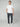 A man stands against a light gray background wearing a white t-shirt, white sneakers, and PROJEK RAW MENS CANVAS BUNGEE RELAXED CARGO PANT in dark gray. He has short light brown hair and his hands are in his pockets.