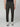 A person models PROJEK RAW MENS CANVAS BUNGEE RELAXED CARGO PANT in black, paired with white sneakers, facing forward against a plain light gray background. The photo is cropped at the shoulders to highlight the pants and shoes.
