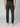 A person stands with their back to the camera in PROJEK RAW MENS CANVAS BUNGEE RELAXED CARGO PANT, featuring dark grey stretch canvas, flap back pockets, black side panels, bungee waistband, and white sneakers against a plain light background.