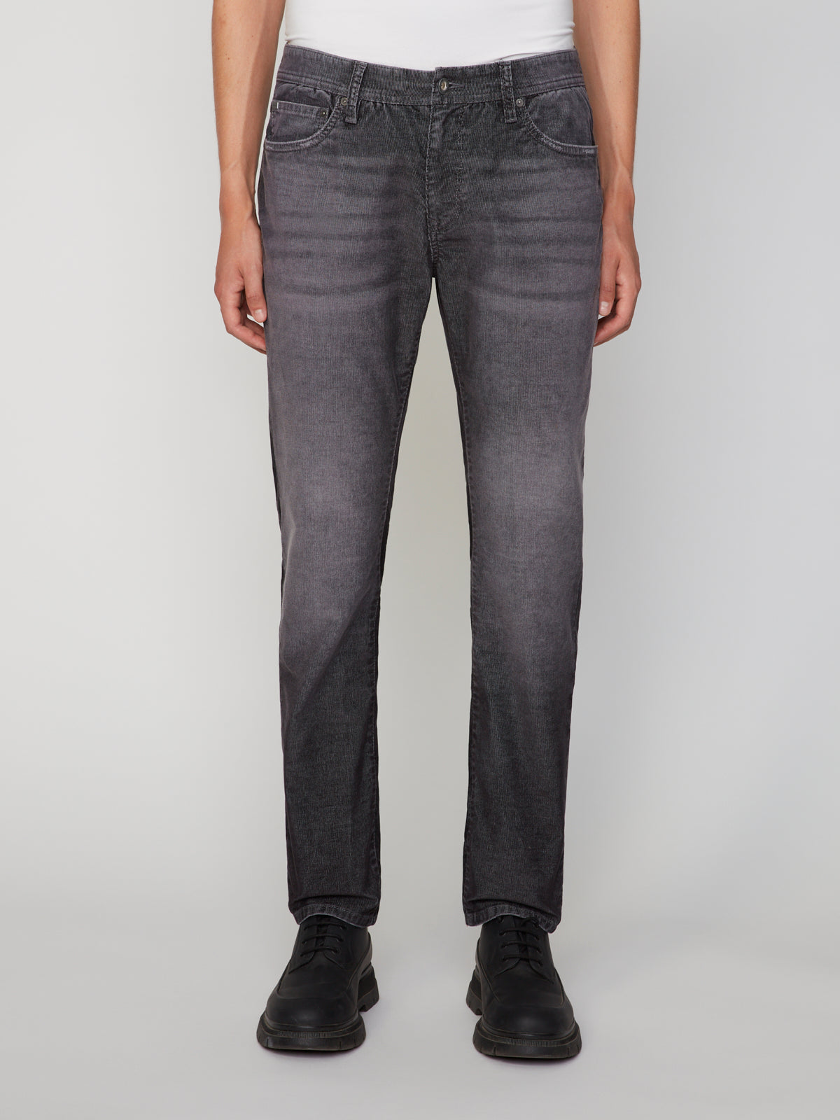 A person models PROJEK RAW MENS BARU5-POCKET STRAIGHT FIT DENIM PANT with a white shirt and black shoes, standing facing forward against a plain light background. The photo is waist-down and highlights the denim pant.