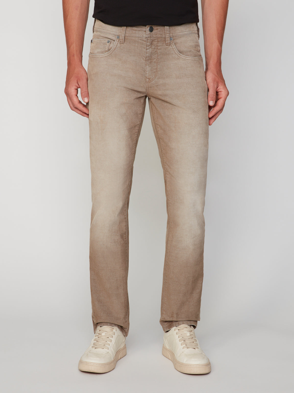A person wears PROJEK RAW MENS BARU5-POCKET STRAIGHT FIT DENIM PANT in light brown, paired with a black shirt and white sneakers, standing facing forward against a plain white background. Photo is cropped from shoulders down.