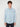 A young man with curly brown hair smiles at the camera, wearing the PROJEK RAW MENS LONG SLEEVES CORDUROY SHIRT in light blue with two chest pockets and black pants, set against a plain white background.