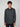 A young man with curly brown hair is wearing a dark gray PROJEK RAW MENS LONG SLEEVES KNIT SHIRT with two chest pockets, standing against a plain light gray background.