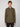A young man with short light brown hair wears the PROJEK RAW MENS LONG SLEEVES KNIT FLANNEL SHIRT in olive green with two chest pockets and dark pants, standing against a plain light gray background, looking at the camera.