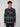 A young man with curly brown hair wears a PROJEK RAW MEN’S LONG SLEEVE FLANNEL SHIRT in black and gray plaid with two chest pockets, standing against a plain light gray background facing forward with a neutral expression.