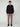 A person stands facing forward against a plain background, wearing the PROJEK RAW MENS LONG SLEEVE FAUX SUEDE OVERSHIRT in black with zippered chest pockets, taupe slim-fit pants, and black shoes—a stylish lightweight layer for any occasion.