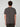 A man with curly brown hair faces away from the camera, wearing a PROJEK RAW MENS SHORT SLEEVE CREW NECK T-SHIRT in dark gray and dark pants, standing against a light gray background.