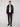 A person stands against a plain background, wearing a black leather jacket, white t-shirt, PROJEK RAW MENS STRETCH SLIM FIT JEAN in black, and black boots, facing forward with a neutral expression.