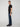 A person with short hair stands sideways against a light gray background, wearing a black t-shirt, black sneakers, and PROJEK RAW MENS BARU STRAIGHT FIT JEAN.
