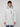 A young man wearing a white PROJEK RAW MENS TEXTURED RIPSTOP ECOFILL QUILTED PARKA WITH HOOD, black beanie, and blue jeans stands facing the camera against a plain light background.