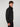 A young man with curly brown hair wears the PROJEK RAW MENS BONDED MICRO SUEDE JACKET, featuring a high collar, as he stands against a plain light gray background looking slightly to the side.