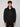 A young man with curly brown hair faces forward, wearing the PROJEK RAW MENS BONDED MICRO SUEDE JACKET in black and black pants, posed against a plain light gray background.