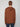 A person with short light brown hair wears the PROJEK RAW MENS HOODED LONG SLEEVE KNIT in brown and dark blue jeans, standing with their back to the camera against a light background, evoking a relaxed, casual style.
