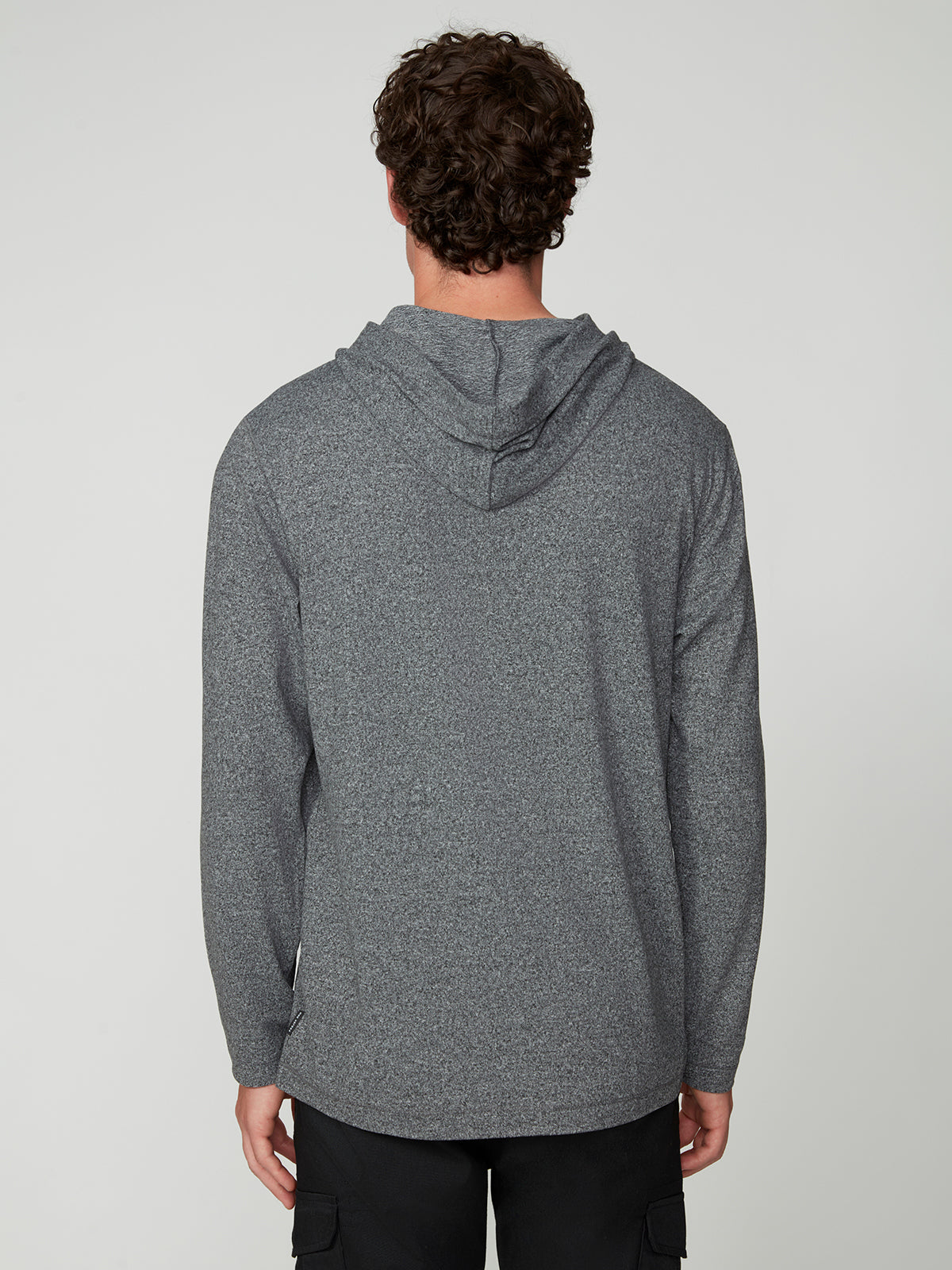 A person with curly brown hair is seen from behind, wearing the PROJEK RAW MENS HOODED LONG SLEEVE KNIT in gray and black pants, creating a casual look against a plain, light background.