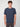 A young man with curly brown hair faces forward, wearing a navy blue PROJEK RAW MENS SHORT SLEEVE CREW NECK GRID JERSEY OVERSIZE TSHIRT and dark pants, set against a plain light background.
