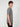 A young man with curly hair stands in profile against a plain background, wearing a PROJEK RAW MENS SHORT SLEEVE CREW NECK GRID JERSEY OVERSIZE TSHIRT in textured gray and black pants, highlighting a relaxed, casual look.