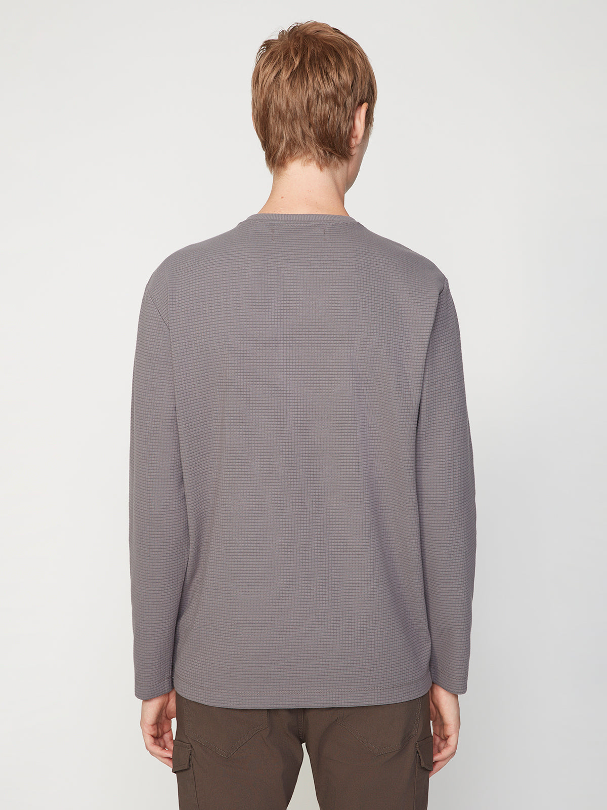 A person with short light brown hair is seen from the back wearing the PROJEK RAW MENS LONG SLEEVE HENLEY GRID JERSEY and dark pants, standing against a plain white background.