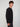 A young man with short curly brown hair stands sideways, wearing the PROJEK RAW MENS LONG SLEEVE CREW NECK paired with dark pants, against a plain light gray background.