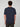 A person with short, curly brown hair stands with their back to the camera, wearing a PROJEK RAW MENS SHORT SLEEVE SCUBA JERSEY RELAXED FIT TSHIRT in navy blue and dark cargo pants, set against a light gray background.
