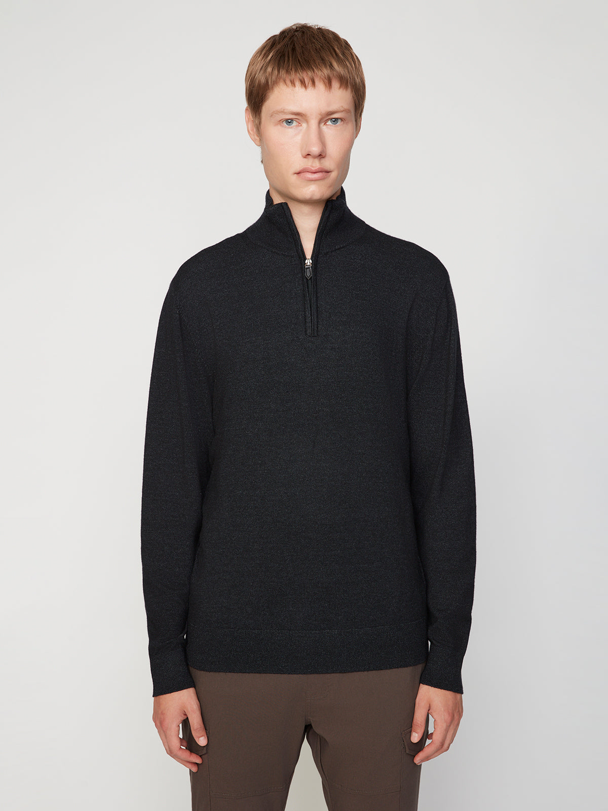 A person with short light brown hair wears a PROJEK RAW MENS 1/4-ZIP CASHMERE TOUCH SWEATER and brown pants, standing facing forward against a plain light background.