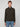 A person with short light brown hair wears a PROJEK RAW MENS 1/4-ZIP CASHMERE TOUCH SWEATER and blue jeans, standing against a plain light gray background and looking directly at the camera.