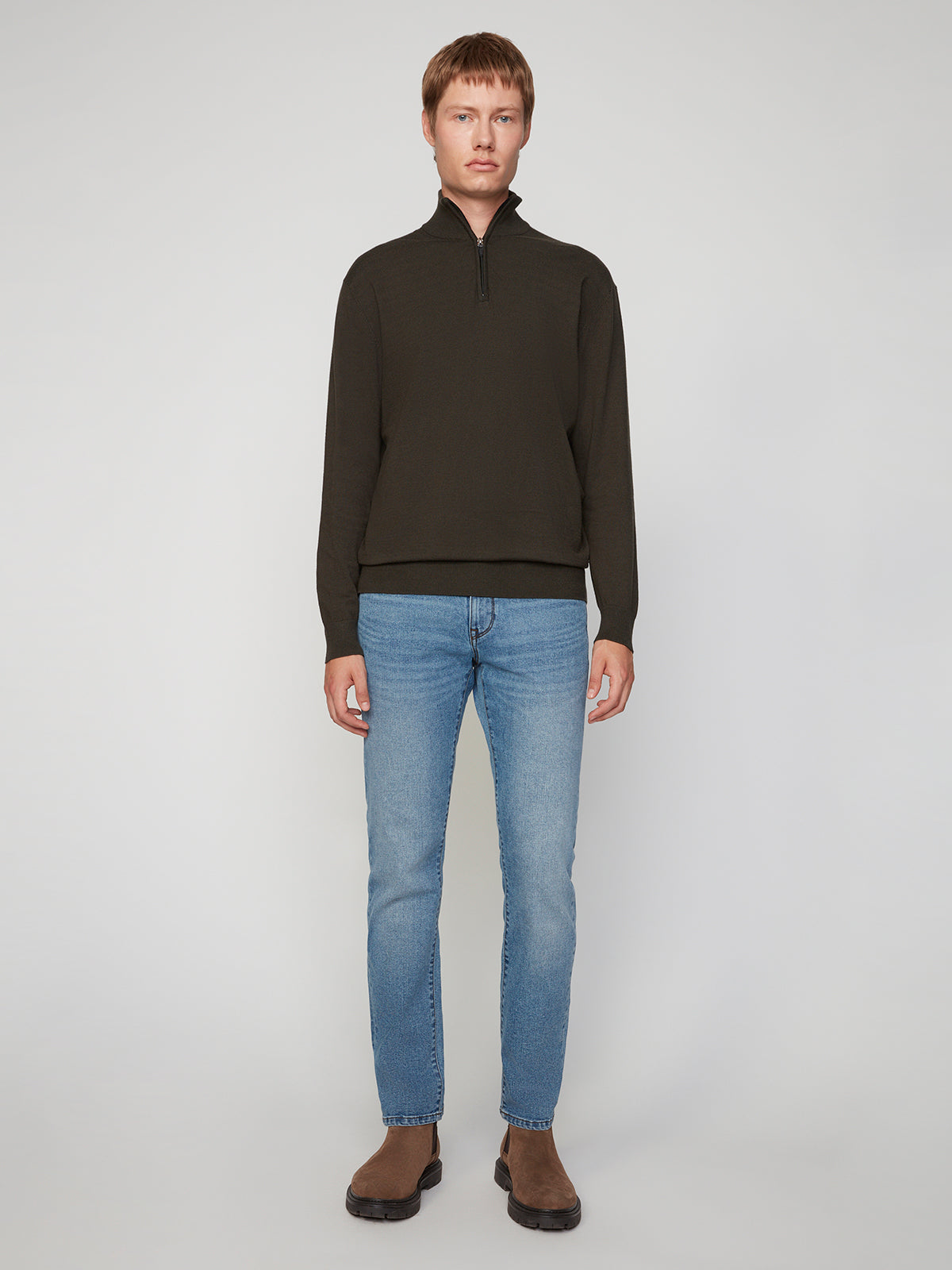A person stands facing forward wearing a PROJEK RAW MENS 1/4-ZIP CASHMERE TOUCH SWEATER with light blue jeans and brown shoes, set against a plain light background.