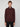 A person with short light brown hair wears a maroon MENS 1/4-ZIP CASHMERE TOUCH SWEATER by PROJEK RAW and black pants, standing against a plain light gray background, looking directly at the camera with a neutral expression.