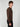 A young man with curly brown hair stands against a light gray background, wearing a PROJEK RAW MENS CREW NECK CASHMERE TOUCH SWEATER in brown and black pants, facing sideways with a neutral expression.