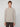 A young person with short light brown hair stands against a plain background, wearing the PROJEK RAW MENS CREW NECK CHENILLE SWEATER in beige and dark pants, facing the camera with a neutral expression.