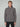 A young man with short light brown hair models the MENS CHENILLE MOCK NECK SWEATER by PROJEK RAW and black pants, standing against a plain light gray background, looking straight at the camera with a neutral expression.
