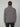 A person with short brown hair is seen from behind wearing the PROJEK RAW MENS CHENILLE MOCK NECK SWEATER in grey and black pants, standing against a plain light grey background.