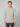 A man with short light brown hair wears the PROJEK RAW MENS CHENILLE MOCK NECK SWEATER in light gray and dark pants, standing against a plain light gray background and looking directly at the camera with a neutral expression.