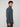 A young man with curly brown hair stands sideways, wearing the PROJEK RAW MENS 1/4 ZIP JACQUARD KNIT MOCK NECK SWEATER and brown pants, looking forward with a neutral expression against a plain light background.