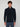 A young man with curly brown hair wears the PROJEK RAW MENS CHENILLE MOCK NECK SWEATER in dark navy and blue pants, standing against a plain light gray background.