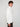 A young man with curly brown hair stands in profile against a plain light background, wearing the PROJEK RAW MENS CHENILLE MOCK NECK SWEATER and dark pants, gazing ahead with a neutral expression.