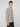 A young man with light brown hair wears the PROJEK RAW MENS FULL ZIPPED KNIT SWEATER BONDED POLAR FLEECE in textured light gray with front pockets and black pants, standing against a white background and looking at the camera.