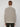 A person with short, light brown hair faces away from the camera, wearing a PROJEK RAW MENS FULL ZIPPED KNIT SWEATER BONDED POLAR FLEECE in light beige and black pants against a plain light background.