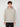 A young person with curly brown hair wears the PROJEK RAW MENS LONG SLEEVE CARBON PEACHED FLEECE HOODIE in light beige and black pants, standing facing forward against a plain, light background.