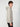 A young man with curly hair models the PROJEK RAW MENS LONG SLEEVE CARBON PEACHED FLEECE HOODIE in light gray and black pants, standing sideways and facing the camera against a plain white background.