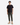A person stands facing forward against a plain white background, wearing a black short-sleeve t-shirt, tan lace-up boots, and olive green PROJEK RAW SOLID BUNGEE PULL ON JOGGER pants featuring an adjustable waist.