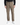 A person wearing the PROJEK RAW SOLID BUNGEE RELAXED FIT CARGO PANT for men, which features utility pockets, along with a black shirt and white sneakers, stands facing forward against a plain white background.
