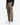 A person is wearing the PROJEK RAW SOLID BUNGEE RELAXED FIT CARGO PANT for men, featuring utility pockets, paired with a black long-sleeve shirt and white sneakers, standing against a plain white background.