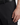 A close-up of a person wearing the PROJEK RAW SOLID BUNGEE LOOSE FIT CARGO PANT for men in black, paired with a black belt, their right hand resting near the utility pocket—showcasing sleek urban wear style.
