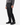 A person wearing a gray sweater, PROJEK RAW SOLID BUNGEE LOOSE FIT CARGO PANT for men with utility pockets in black, and black lace-up boots stands against a white background.