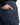A person wearing PROJEK RAW SOLID BUNGEE LOOSE FIT CARGO PANT for men in navy blue, with their hand partially in the front utility pocket, paired with a black sweater.