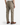 A person wearing the PROJEK RAW SOLID BUNGEE LOOSE FIT CARGO PANT in light brown paired with brown Chelsea boots stands with their back to the camera, highlighting the rear view and side utility pockets of the pants.