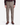 A person stands facing forward against a plain white background, dressed in PROJEK RAW’s SOLID BUNGEE LOOSE FIT CARGO PANT for men—tan pants featuring utility pockets—paired with a dark plaid shirt and brown boots.